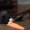 Incensário decorativo em formato de cenoura com pequeno monge zen para incenso de vareta.