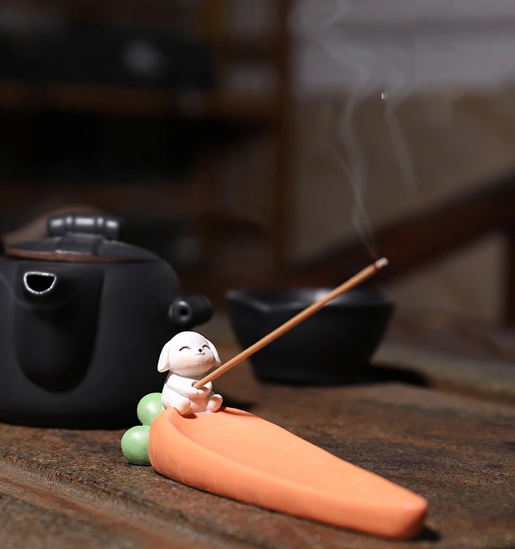 Incensário decorativo em formato de cenoura com pequeno monge zen para incenso de vareta.
