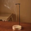 Incensário suspenso minimalista em madeira com suporte metálico para incensos de vareta.