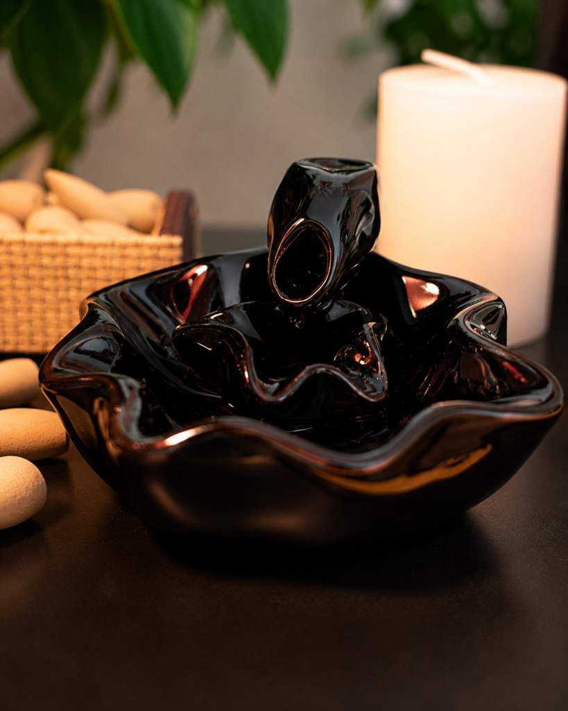 Incensário cascata decorativo flor de lótus produzido em cerâmica com efeito visual de fumaça descendente.