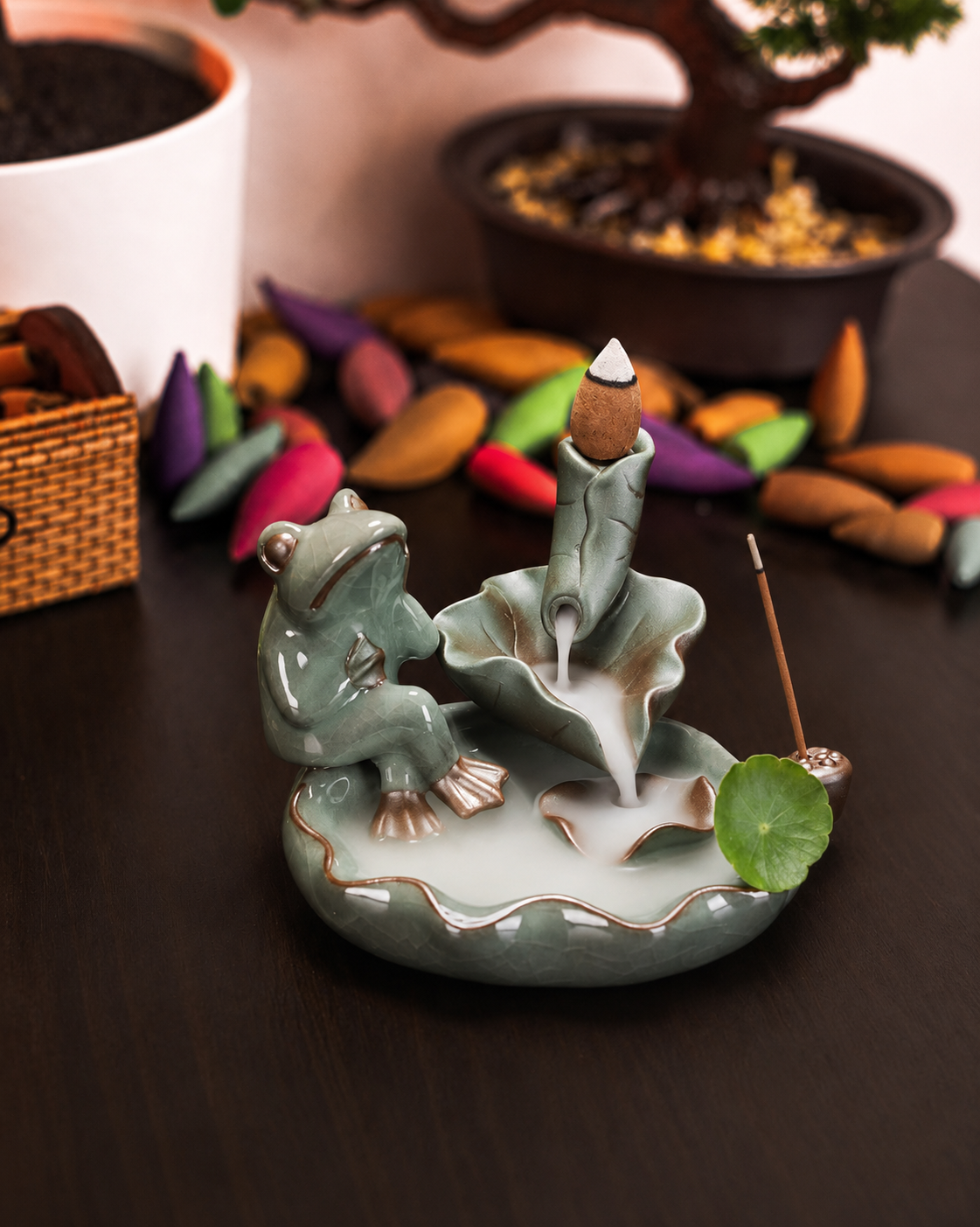 Incensário cascata decorativo de cerâmica com sapo e folhas de lótus criando efeito visual de fumaça descendente.