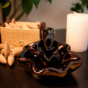 Incensário cascata decorativo flor de lótus produzido em cerâmica com efeito visual de fumaça descendente.