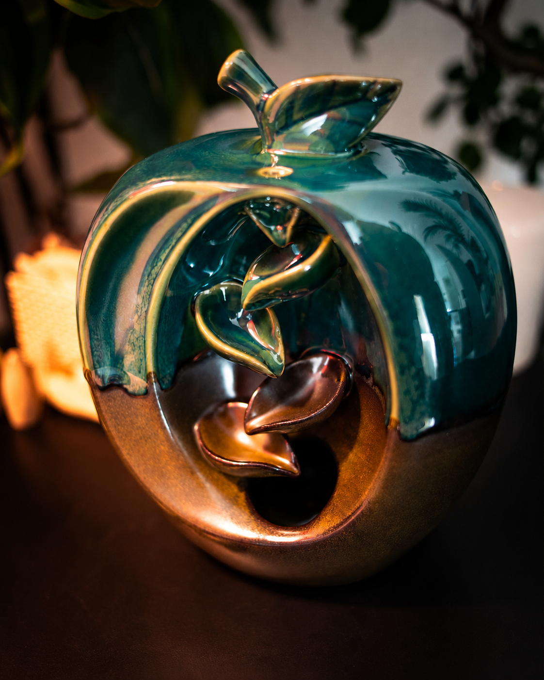 Incensário cascata decorativo em formato de maçã produzido em cerâmica com efeito visual de fumaça descendente.