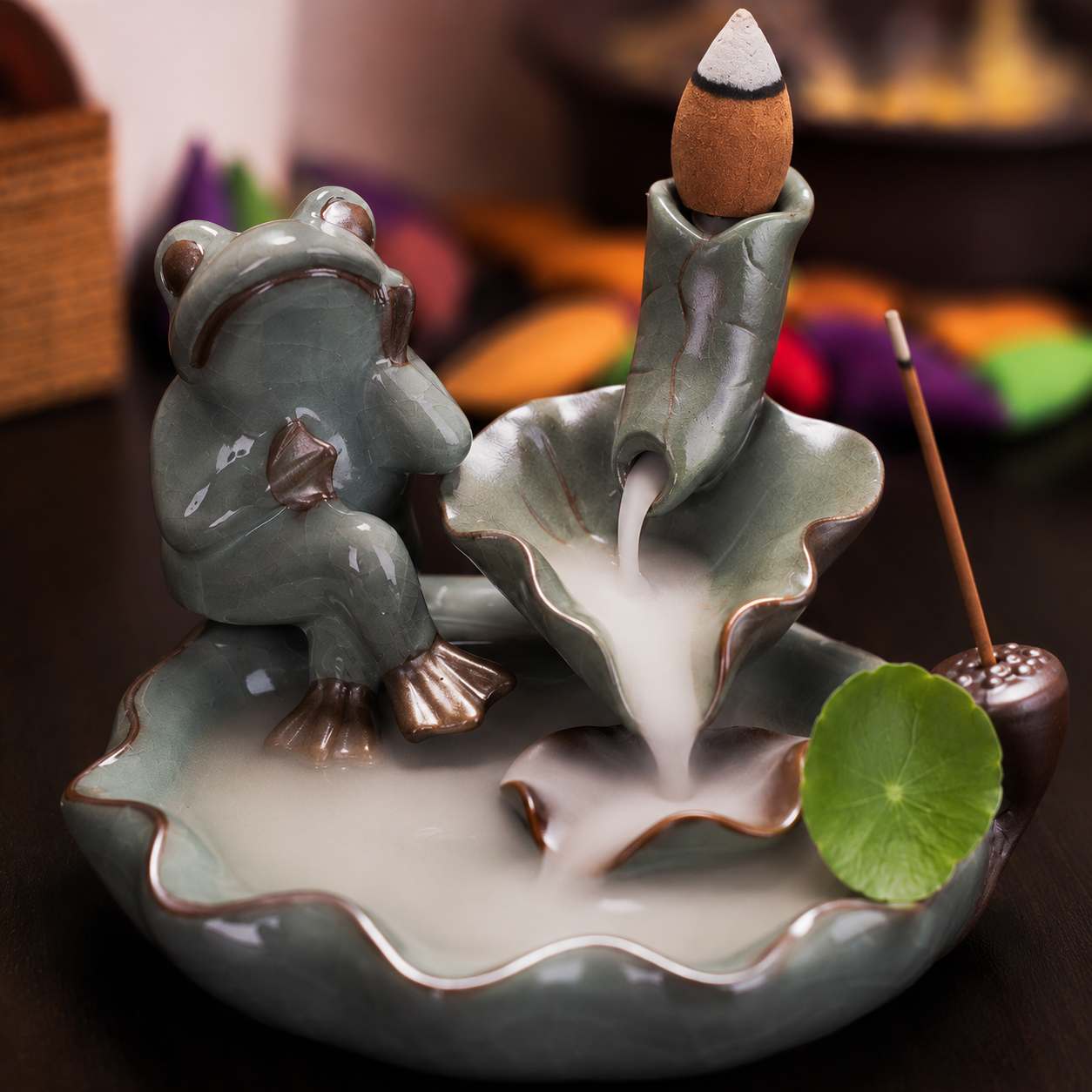 Incensário cascata decorativo de cerâmica com sapo e folhas de lótus criando efeito visual de fumaça descendente.